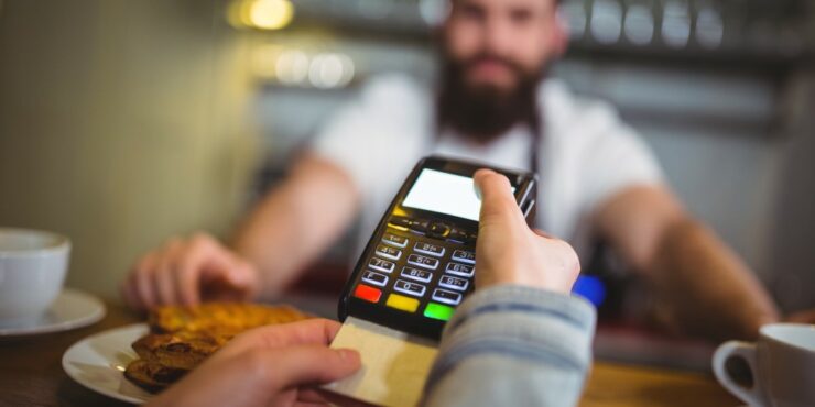 Consumidora paga uma compra com cartão de crédito em loja.