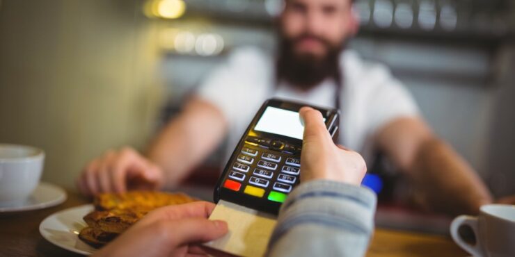 impactos-registro-de-recebiveis Consumidora paga uma compra com cartão de crédito em loja.